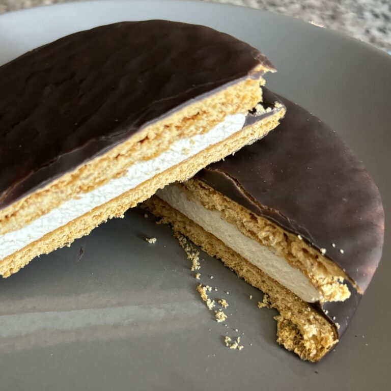 A sliced dessert sandwich with chocolate outside and a cream filling