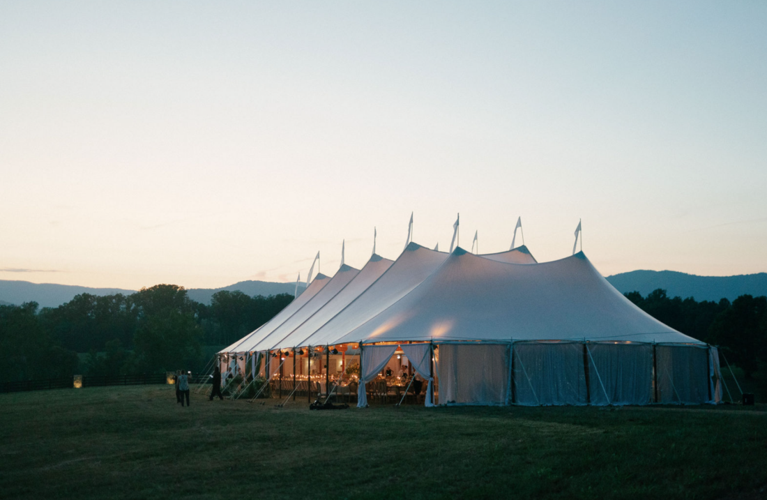a white event tent at dusk with the Blue Ridge Mountains in the background
