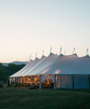 a white event tent at dusk with the Blue Ridge Mountains in the background