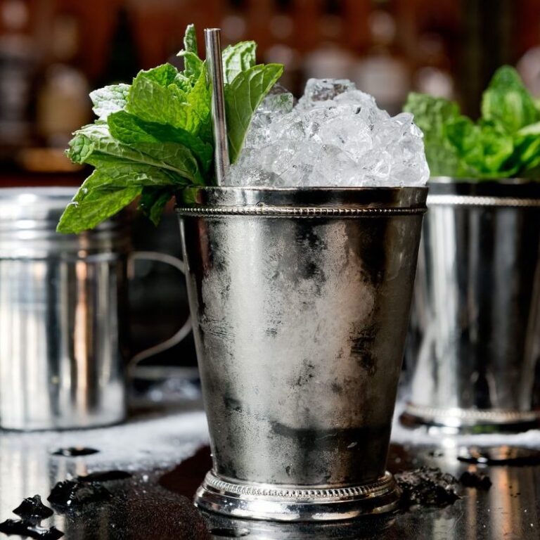 A silver cup with ice and mint
