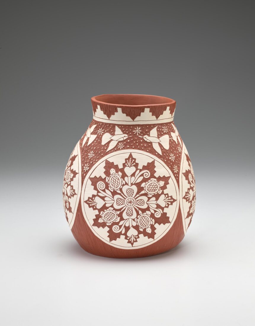 A clay vessel with a white glaze in a pattern.