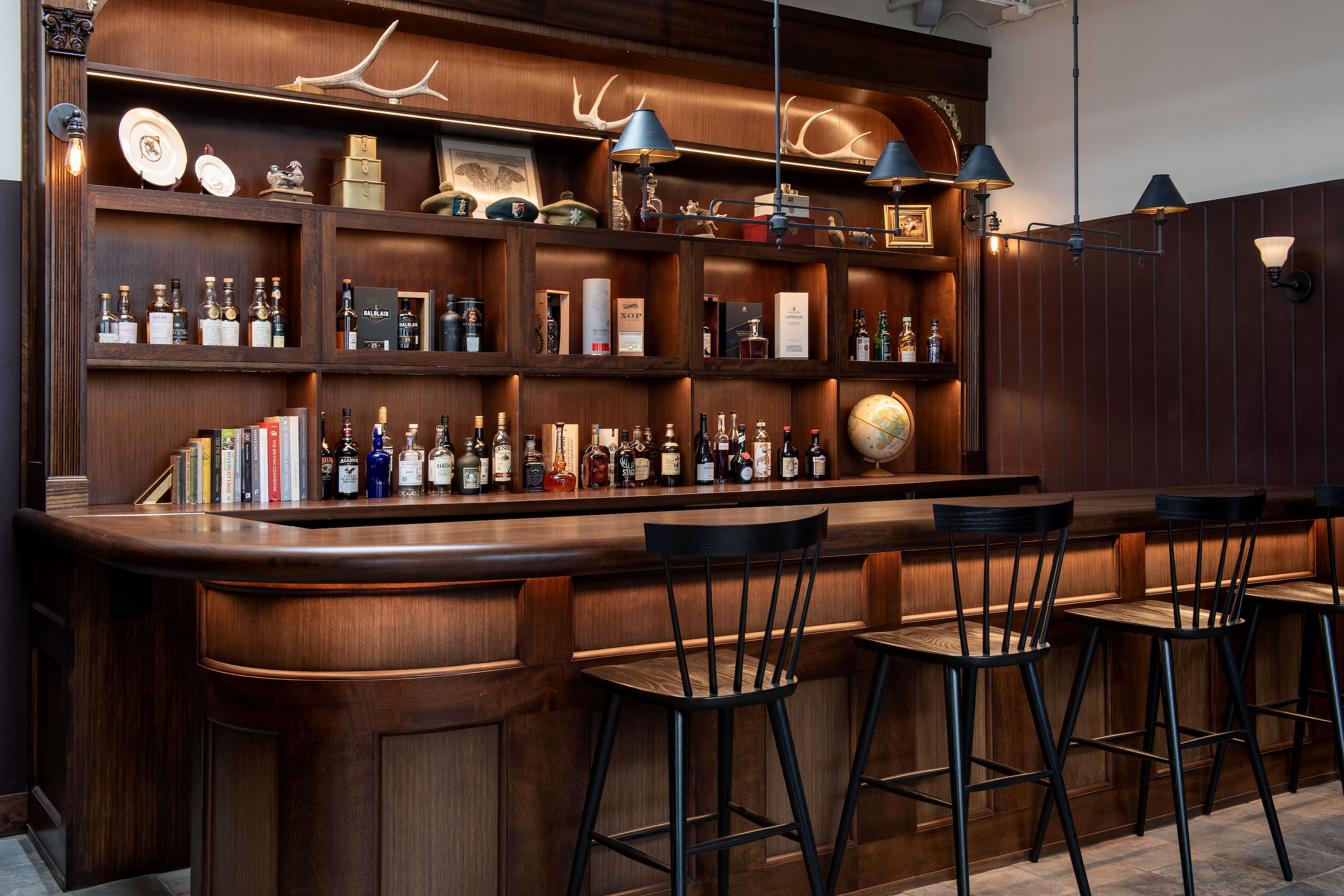 A wood bar with antlers and bottles