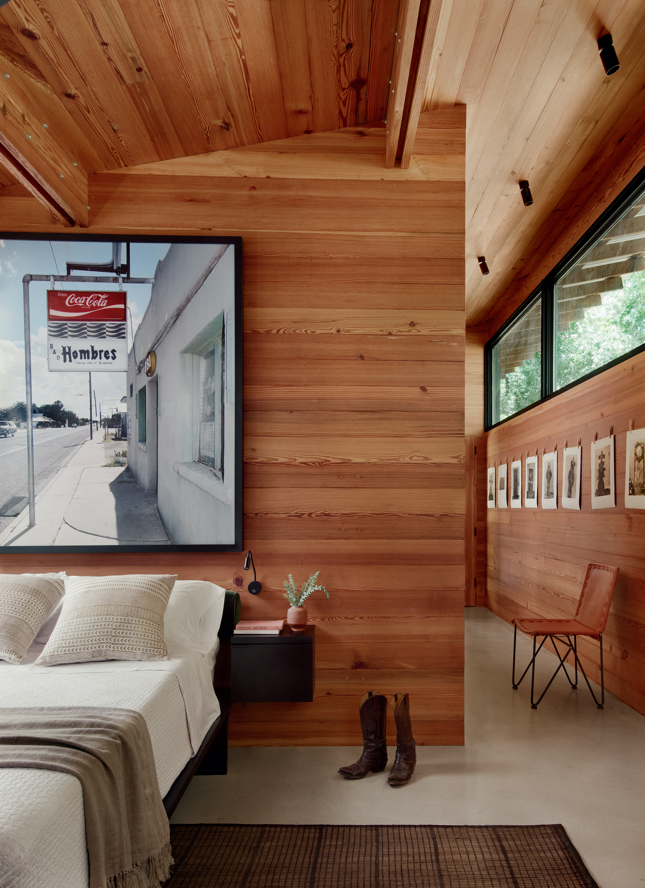 A bedroom with wood walls and a framed photo of a street store sign