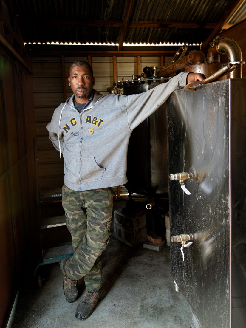 A man stands by a water vat