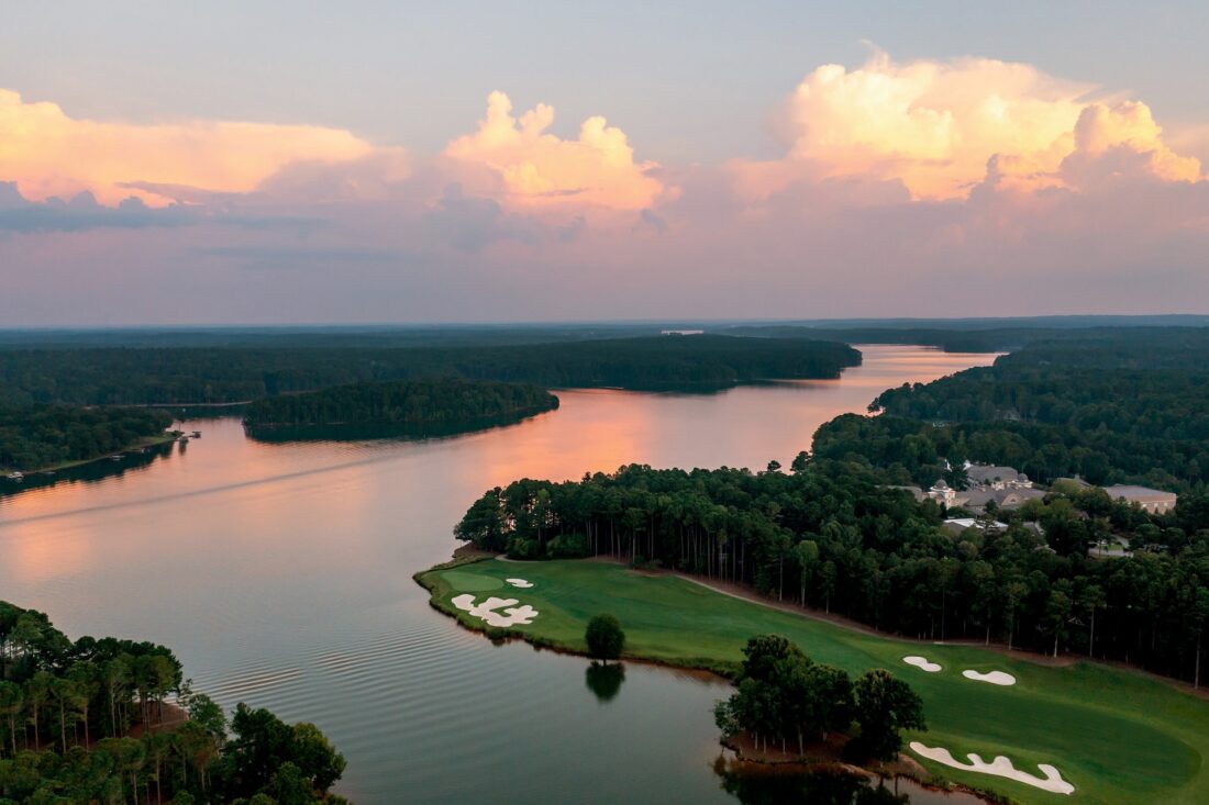 a gulf course along a river bank at sunset