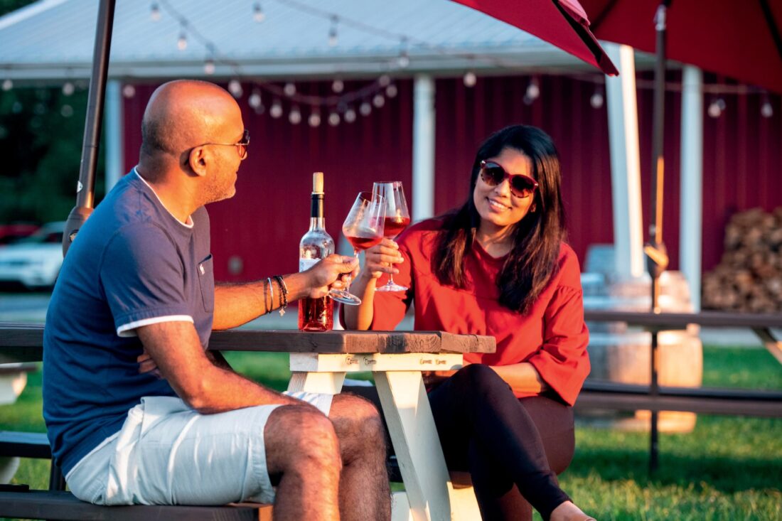 A couple cheering under a patio umbrella