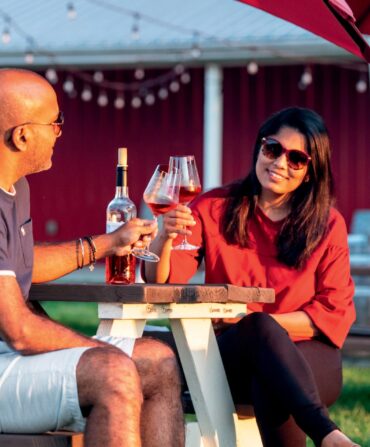 A couple cheering under a patio umbrella