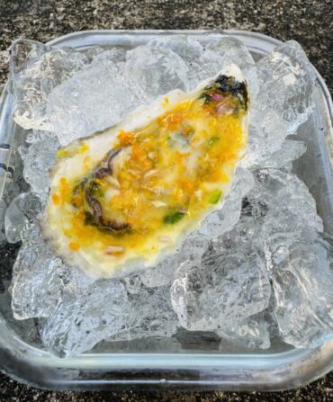 An oyster with orange dressing