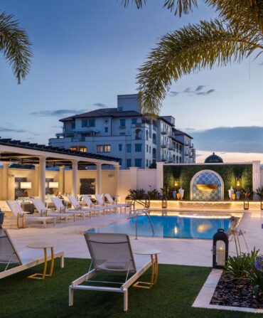 A pool with cabanas around it.