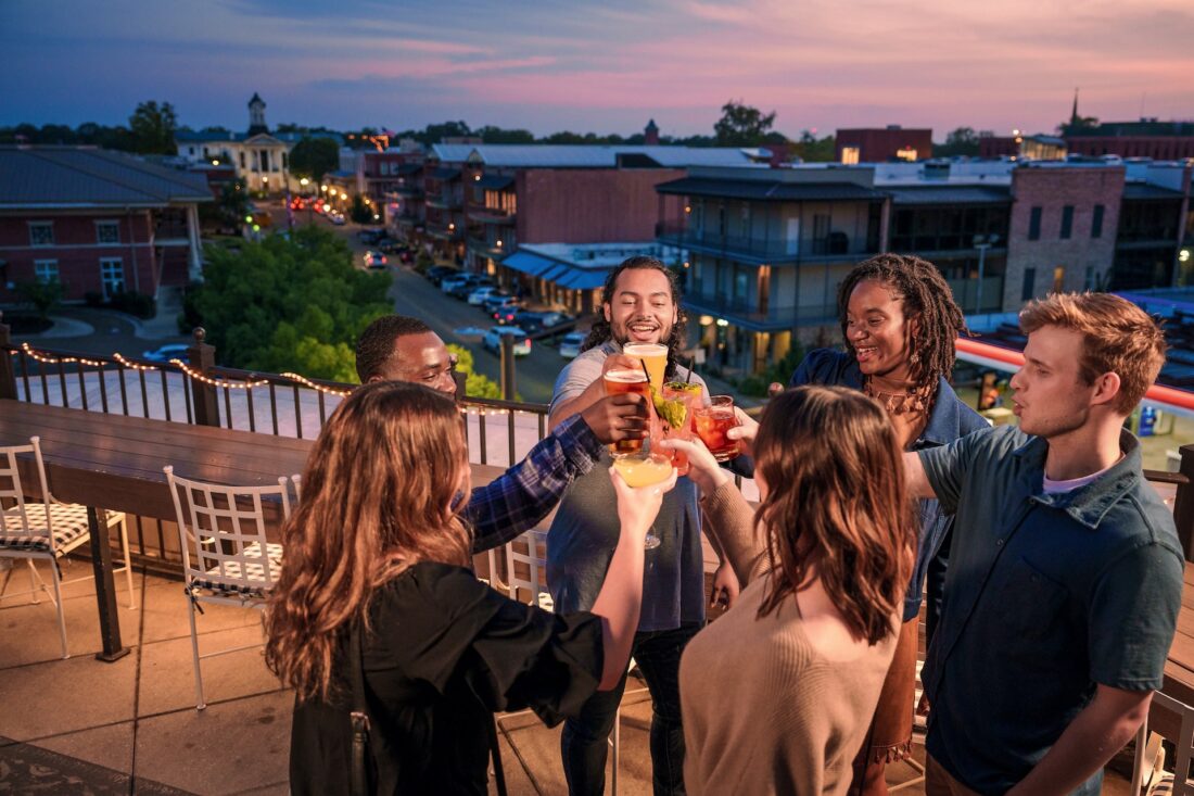 a group cheersing on a rooftop at sunset