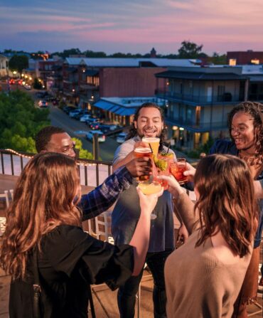 a group cheersing on a rooftop at sunset