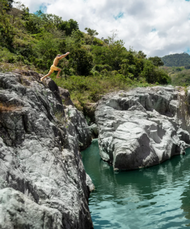 A person jumping into water from a rock