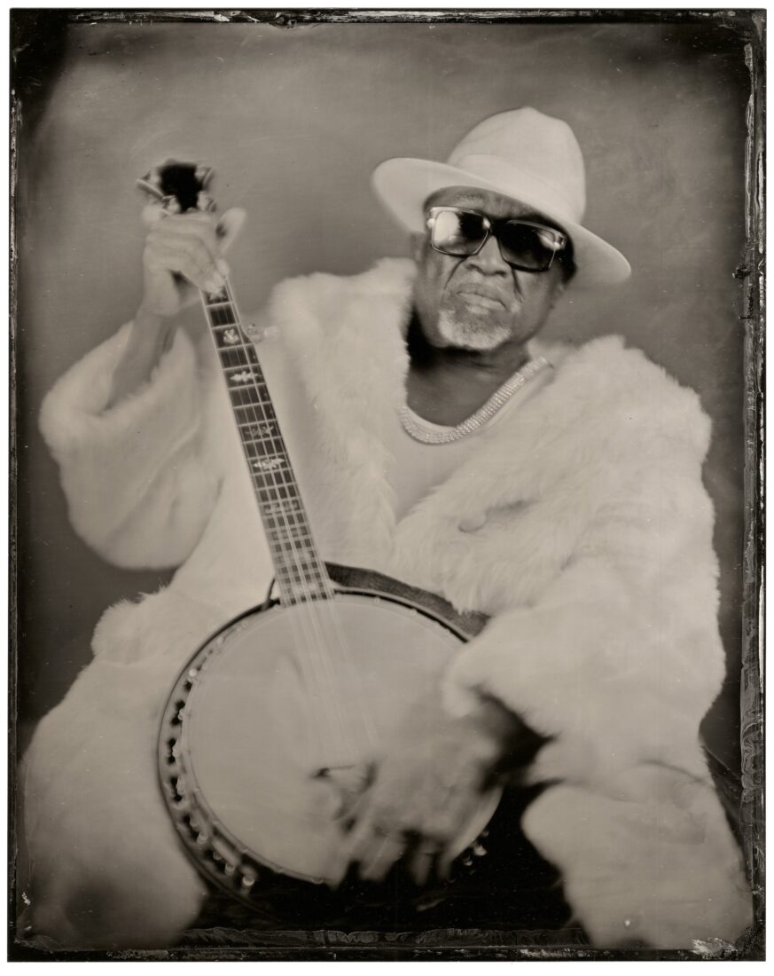 A black and white photo of a man with a banjo