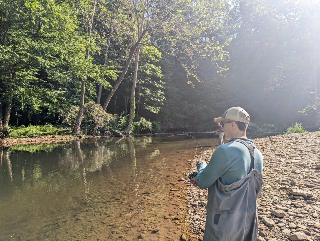 A man fishing in a creek