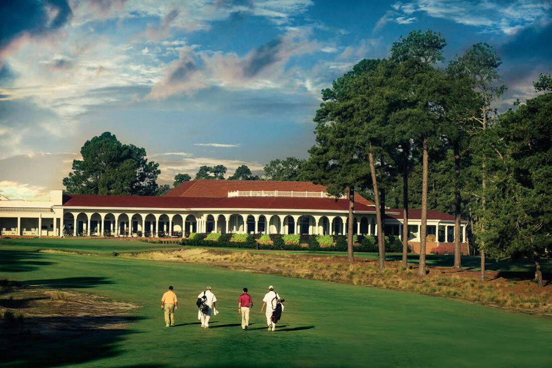 Golfers walk on a green