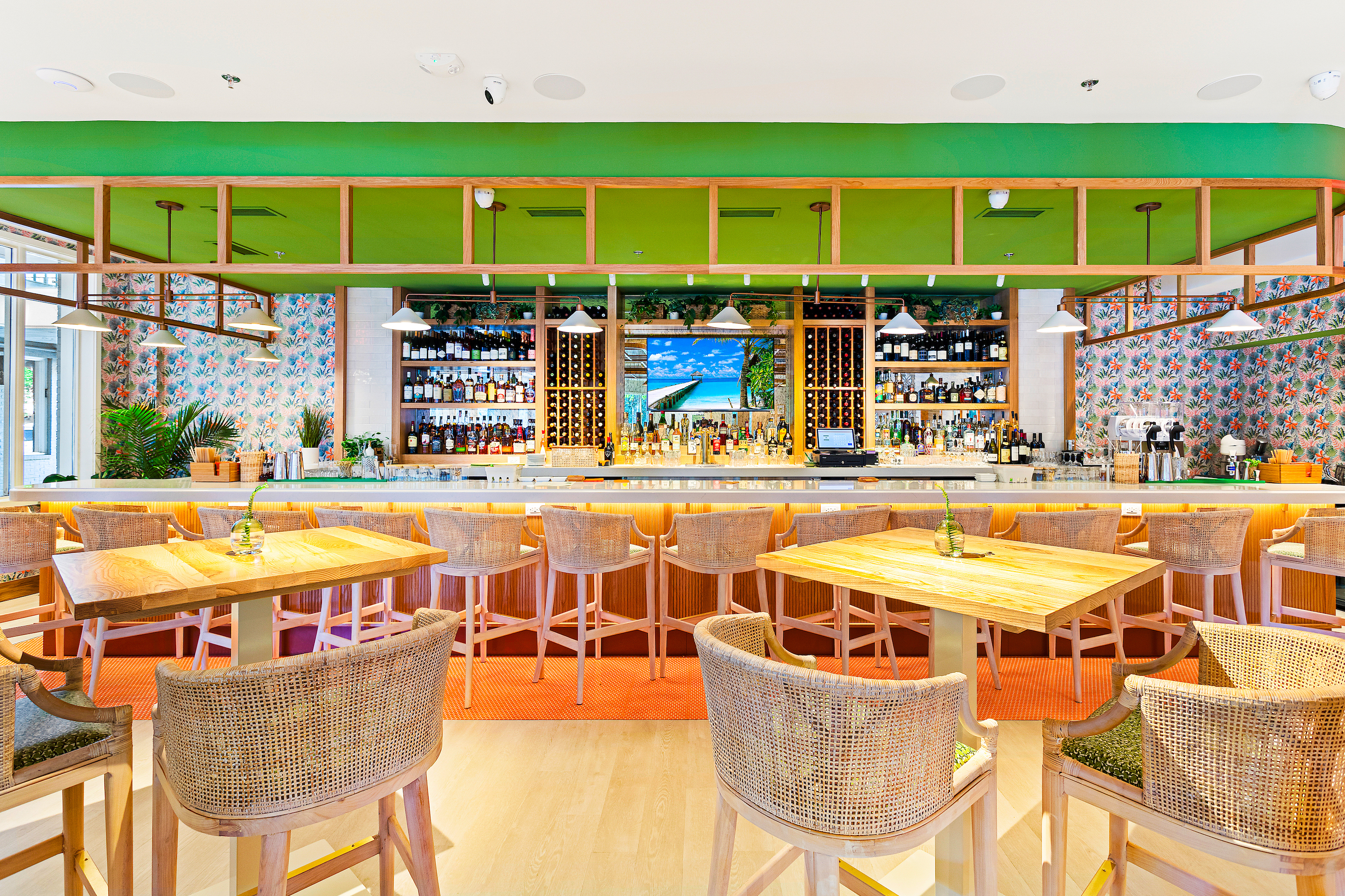 A bar with green wallpaper and tropical colors