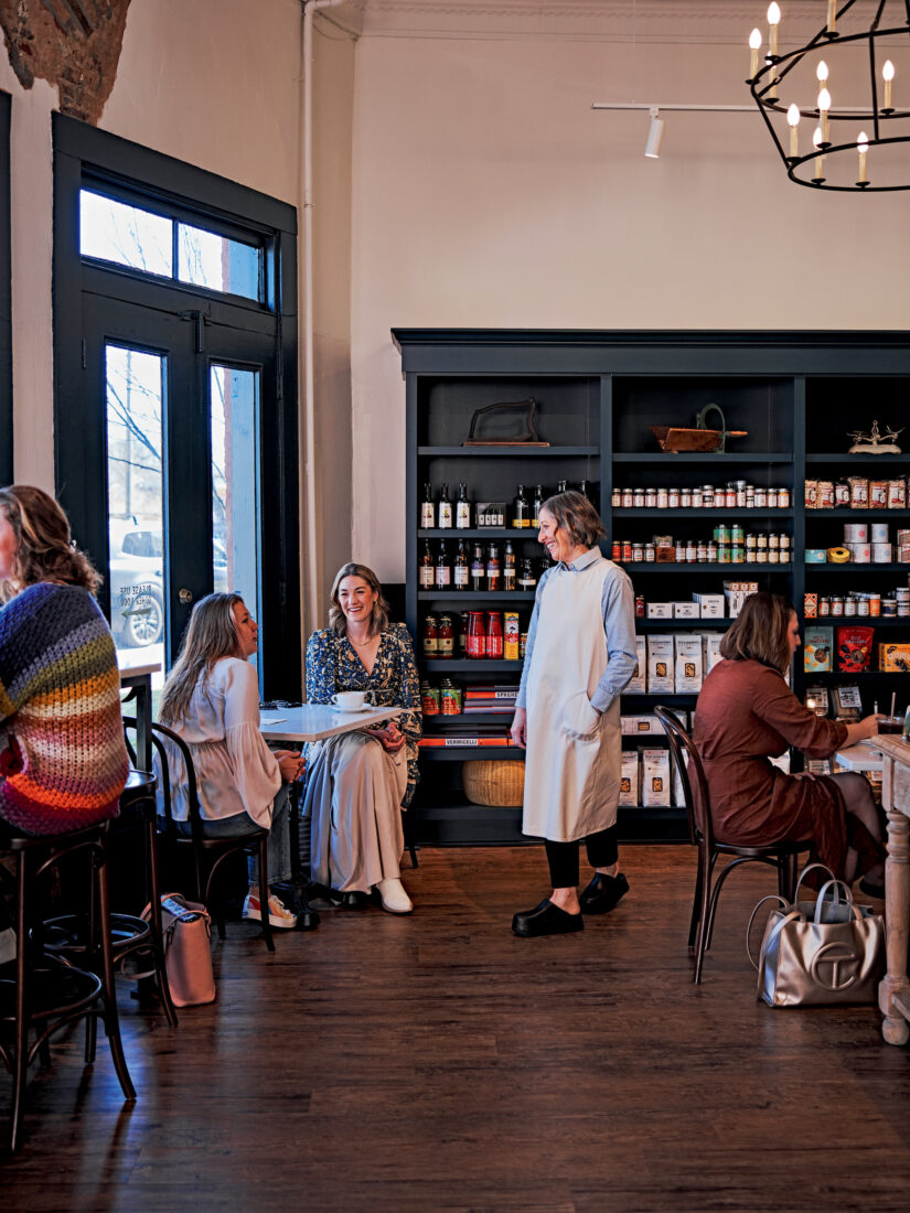 A woman in a cafe talks to guests