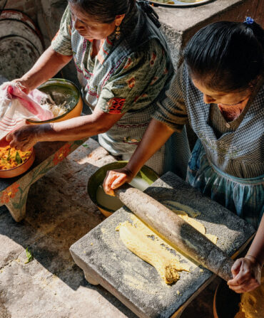 Two women prepare quesadillas with squash blossoms in Teotitlán del Valle, near Oaxaca.