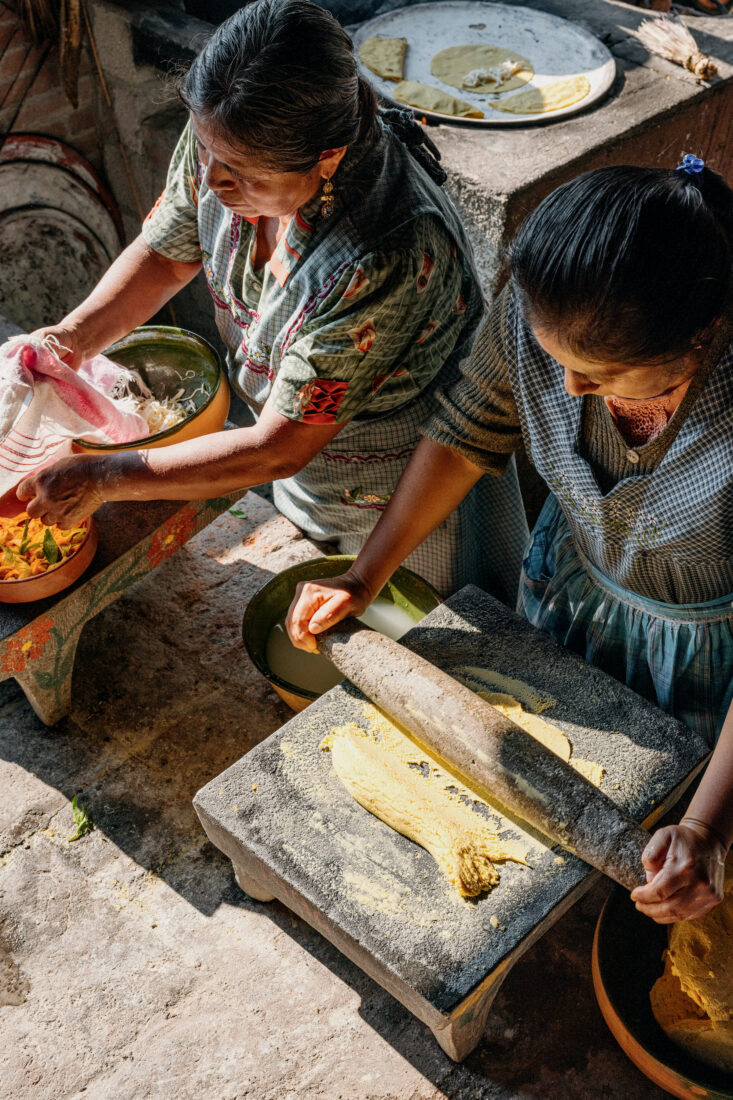 Two women prepare quesadillas with squash blossoms in Teotitlán del Valle, near Oaxaca.