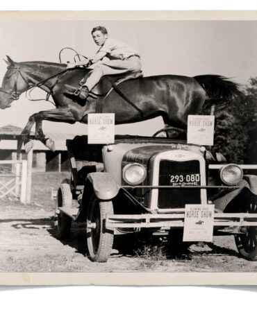 A boy riding a horse jumps over a car