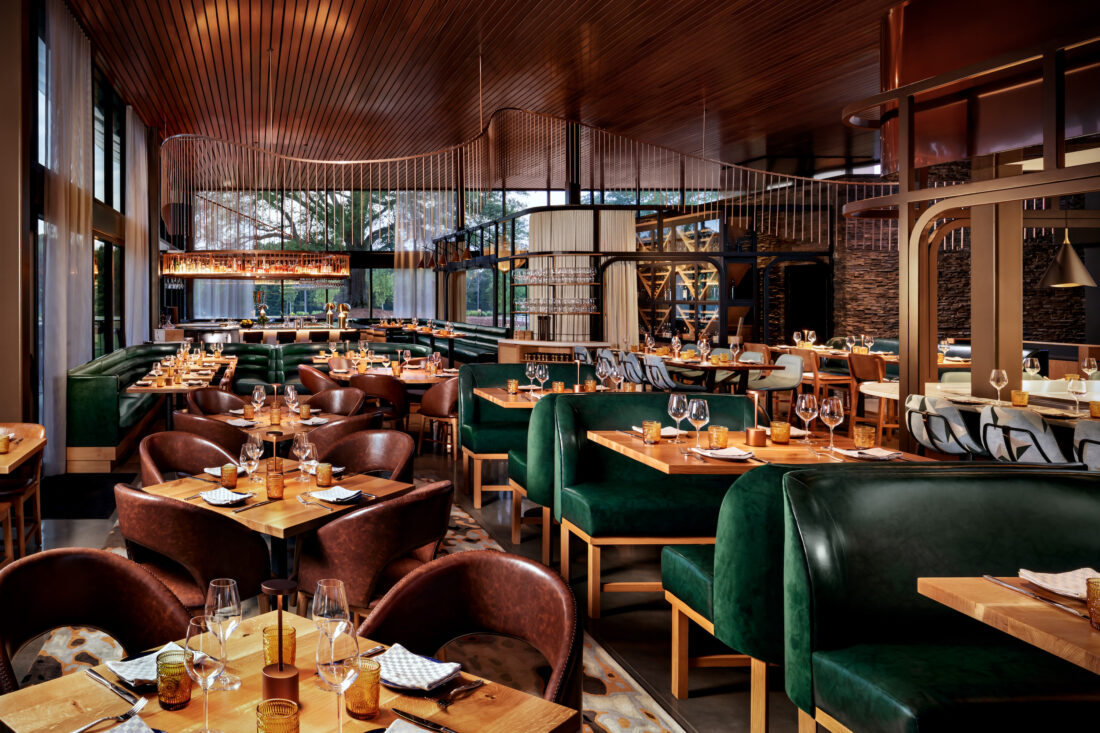 A dining room of a restaurant with green booths