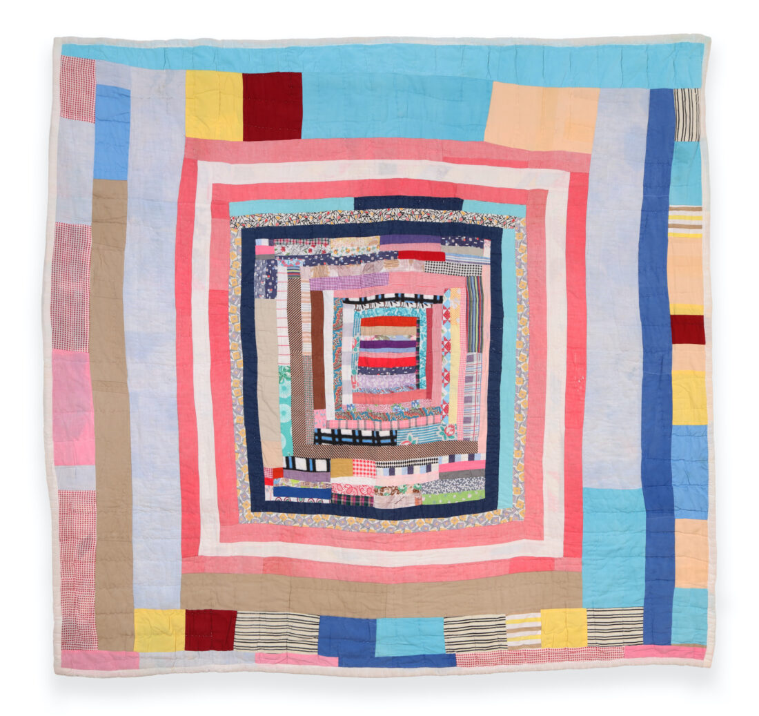 A housetop quilt with blue, pink, white, yellow, and red fabric