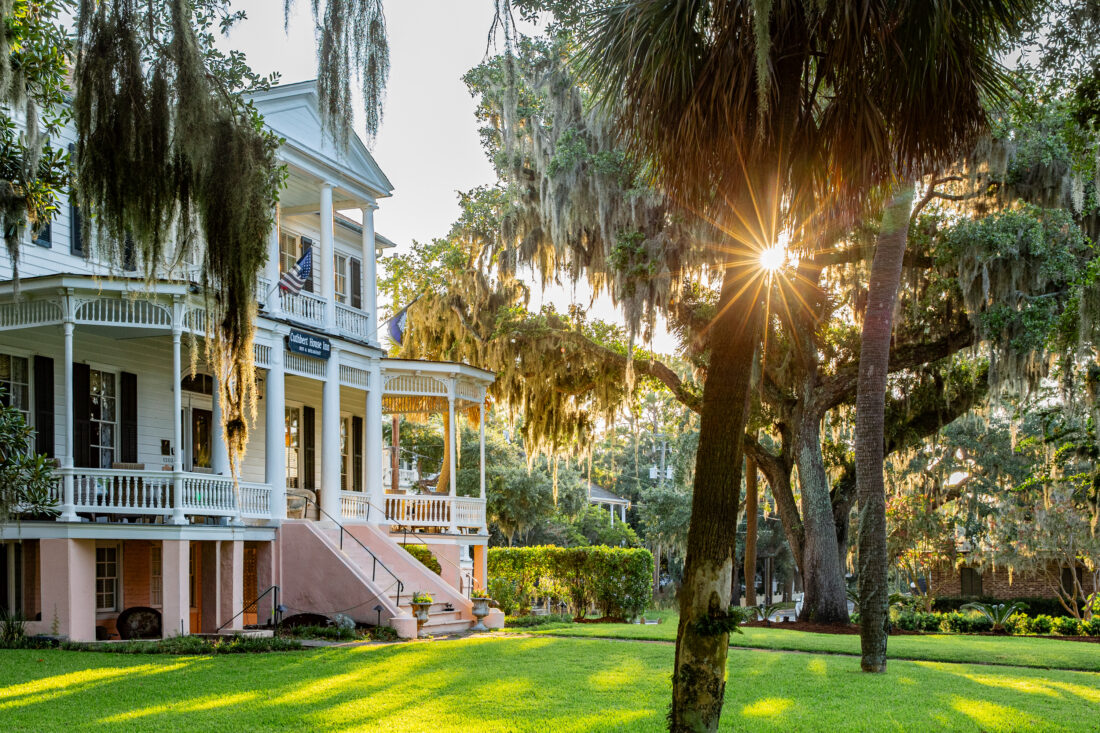 An old home with a large front yard with trees