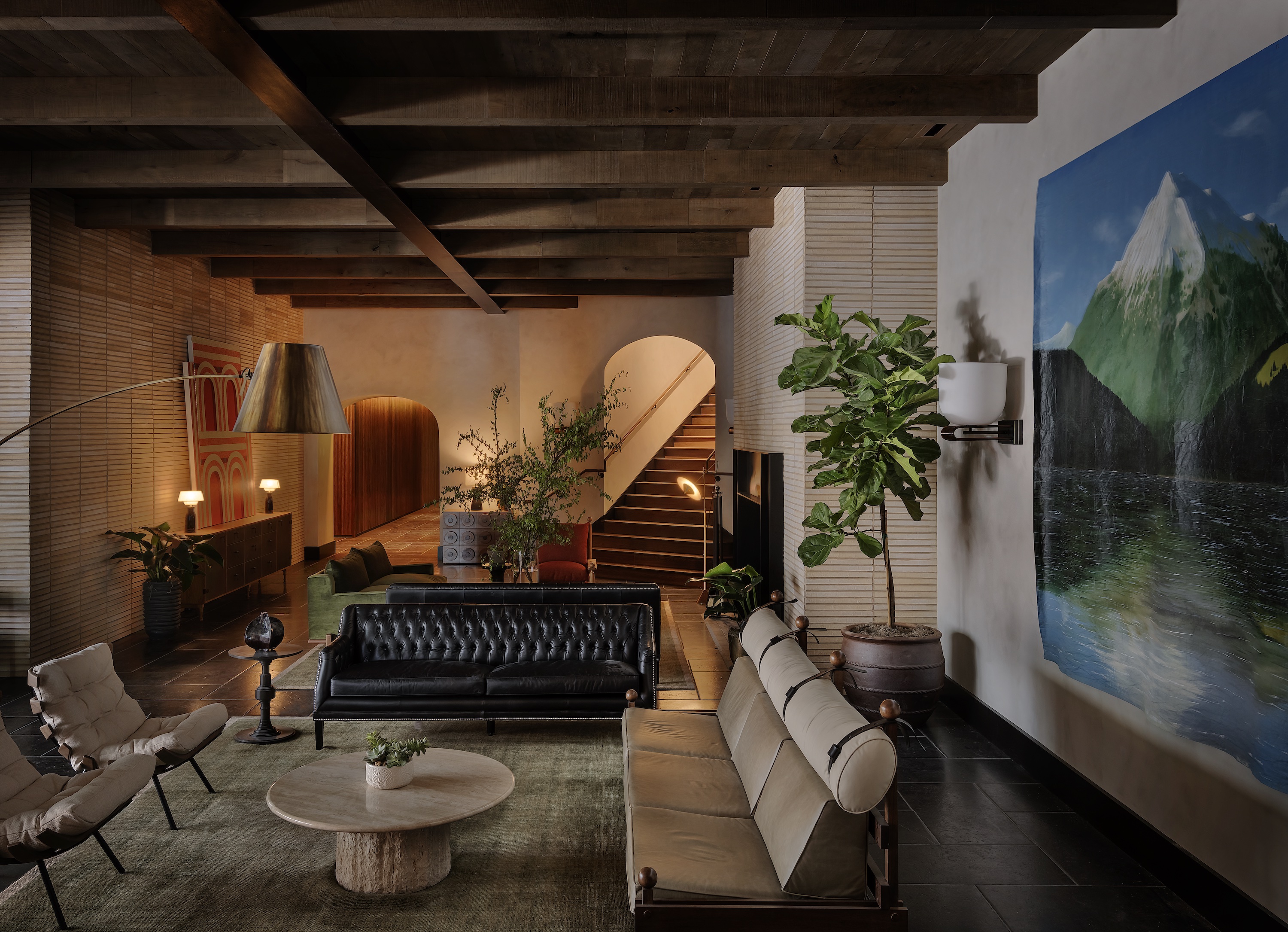 Inside a hotel lobby with warm lights, dark wood and curved doors