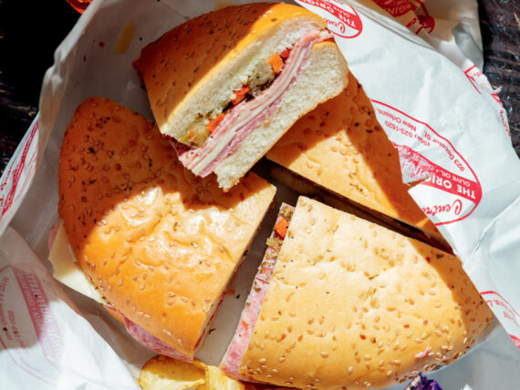 A muffuletta in a basket with chips