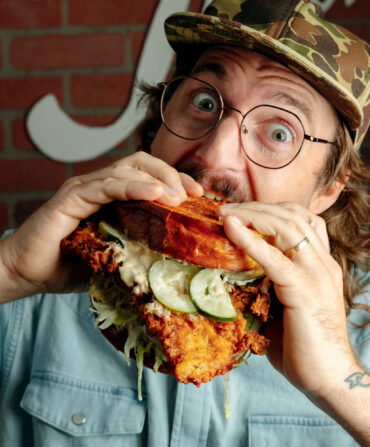 A man eats a large sandwich