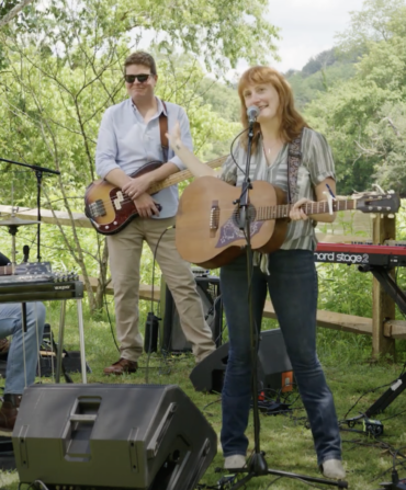 A band plays outside under some trees