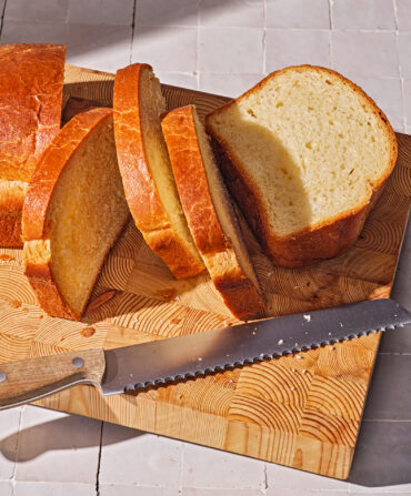 A cut loaf of bread on a wood board