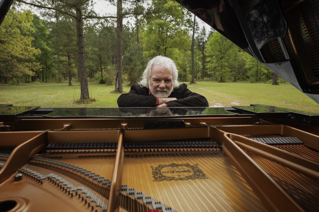 Chuck Leavell leans over his piano on his land