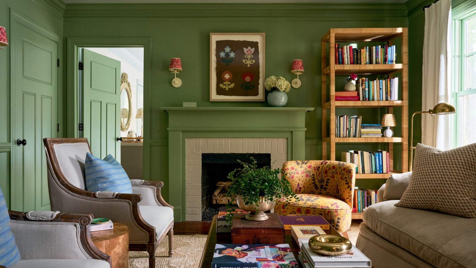 A green living room with colorful book cases