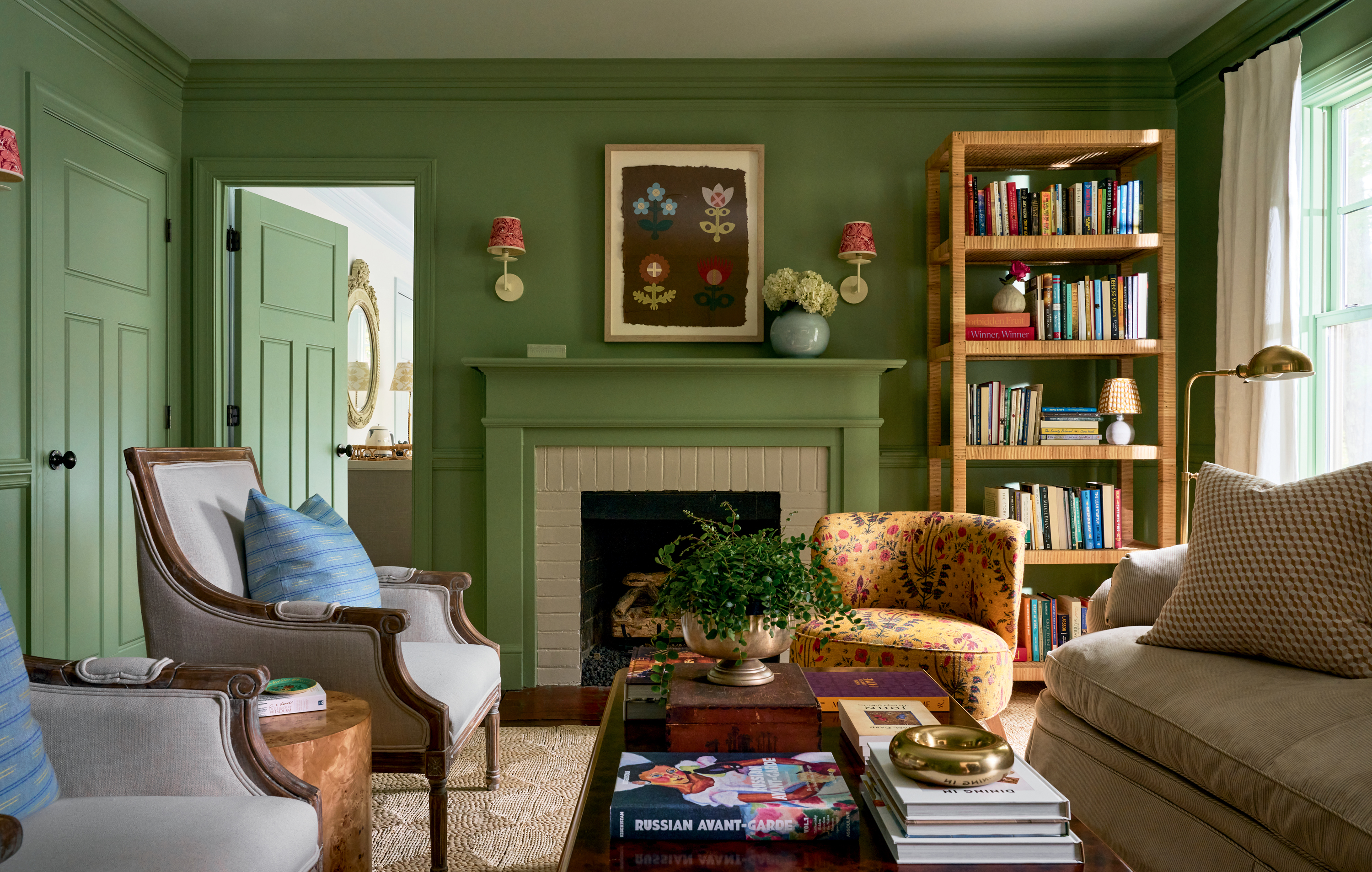 A green living room with colorful bookshelves