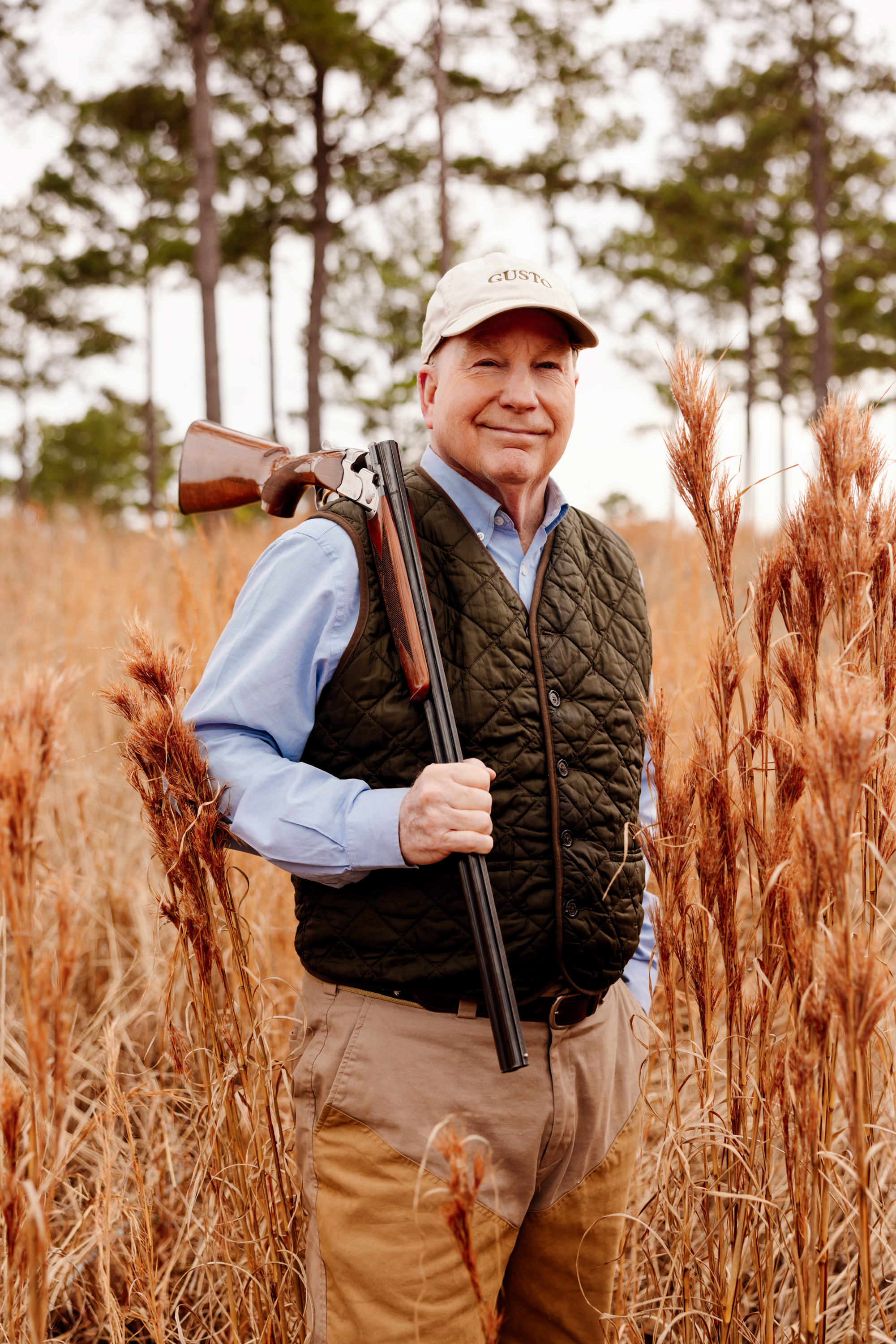 A portrait of a man in a field with a gun