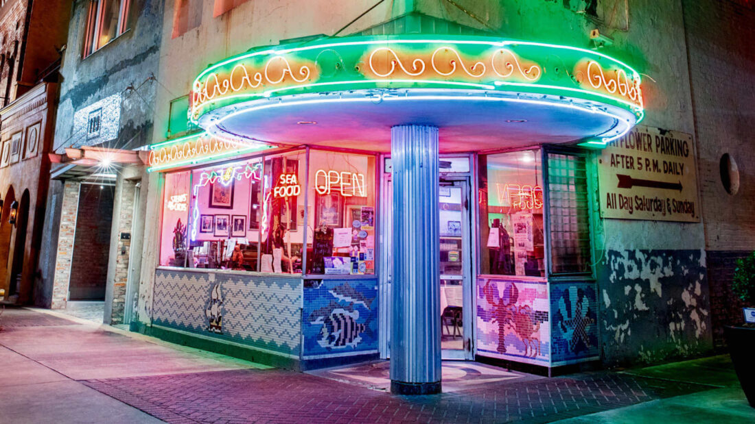 A neon restaurant corner with lights and tile seafood