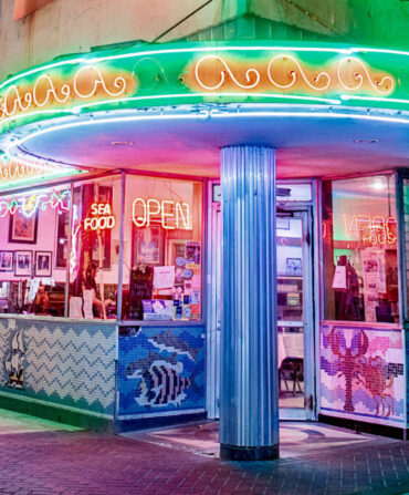 A neon restaurant corner with lights and tile seafood