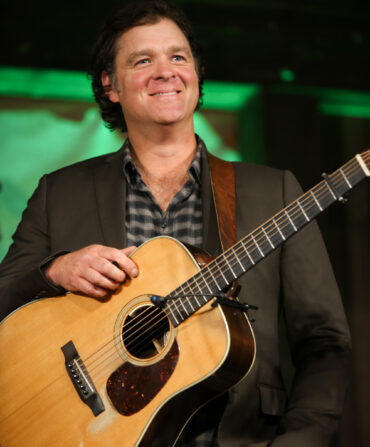 A man holds a guitar