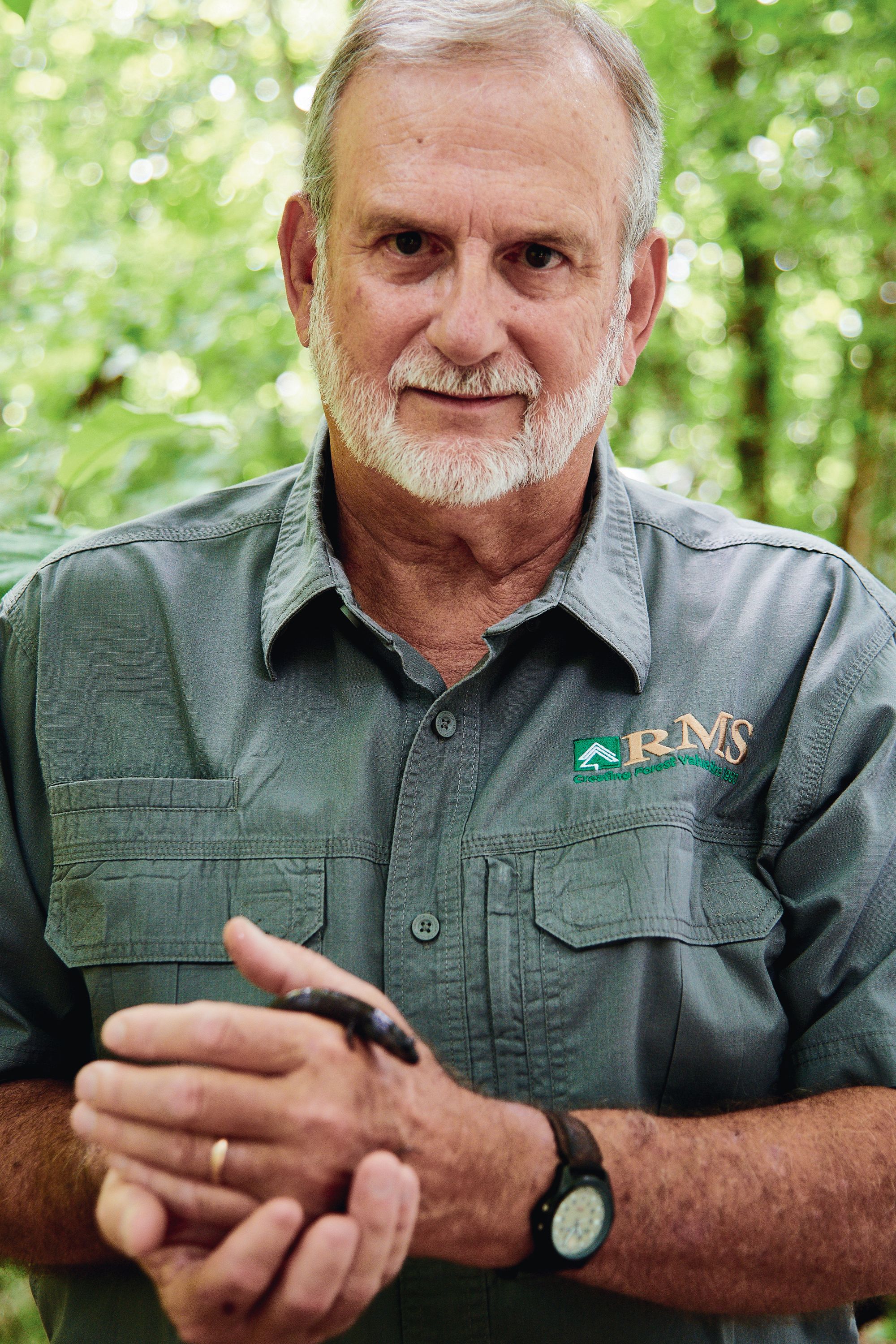 A man in the field holds a salamander