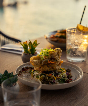 A plate of fried fish on a slaw by the water