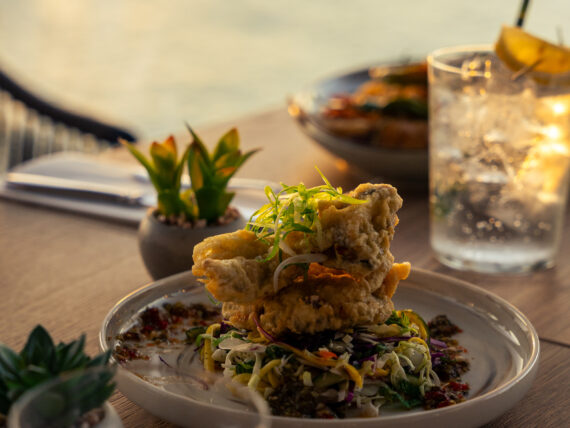 A plate of fried fish on a slaw by the water