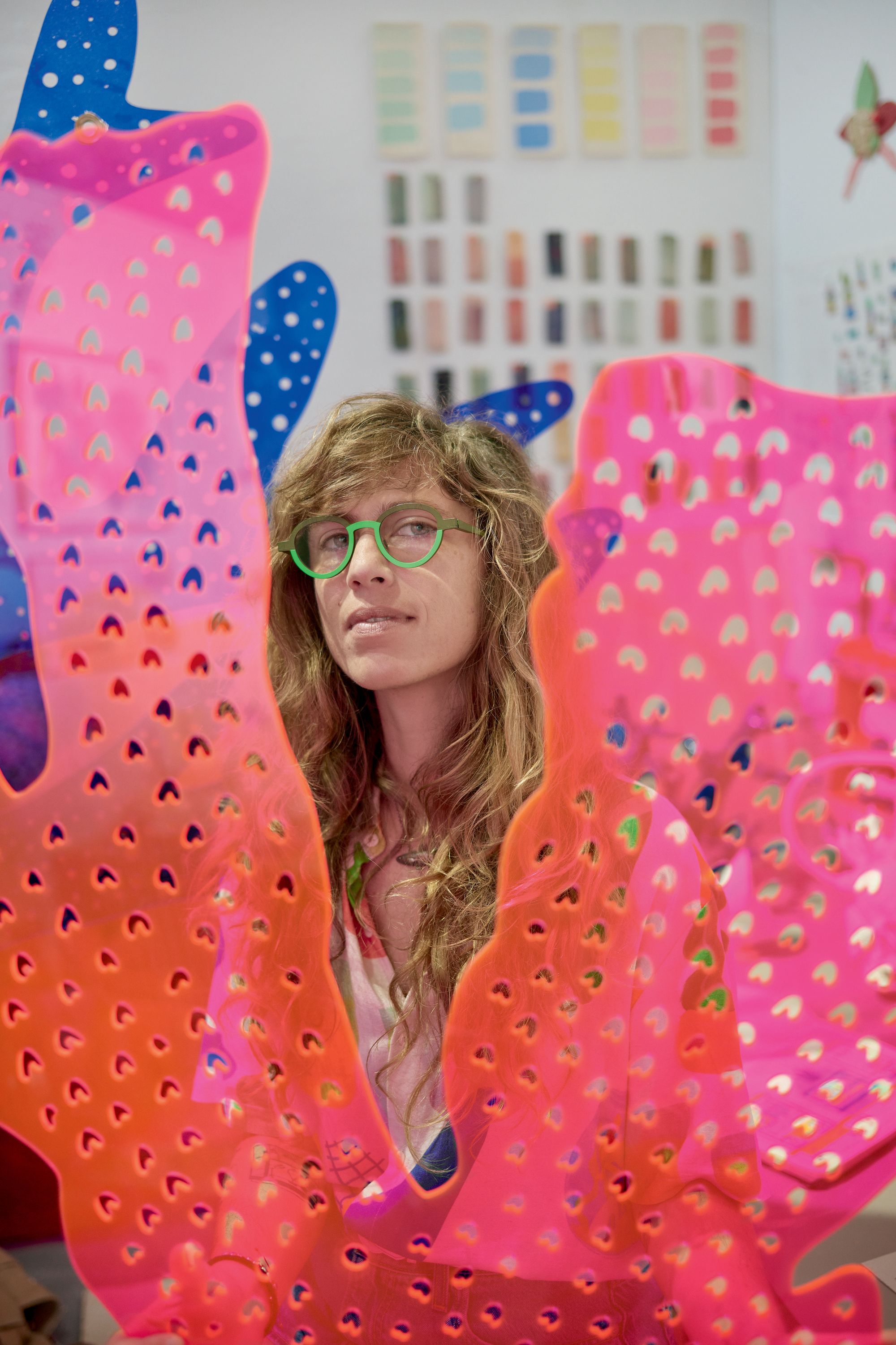 A portrait of a woman behind pink plexiglass coral