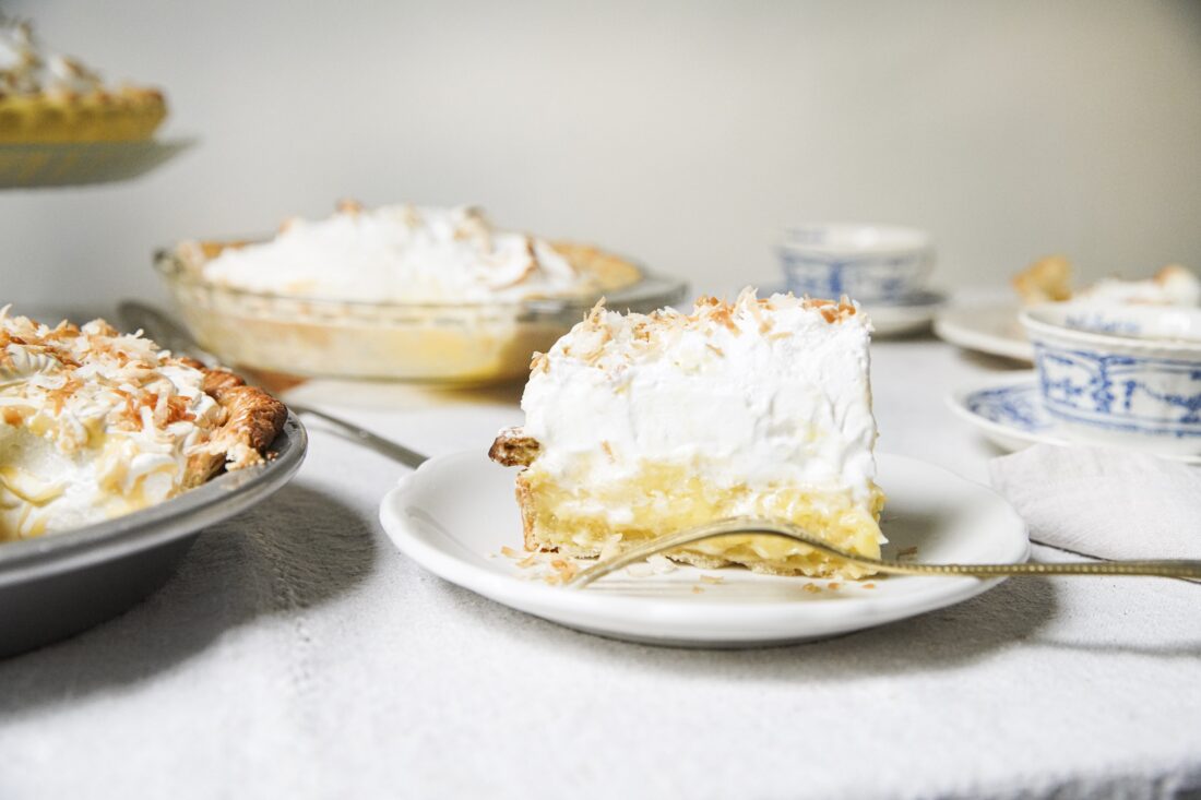 A slice of coconut cream pie with meringue on top.