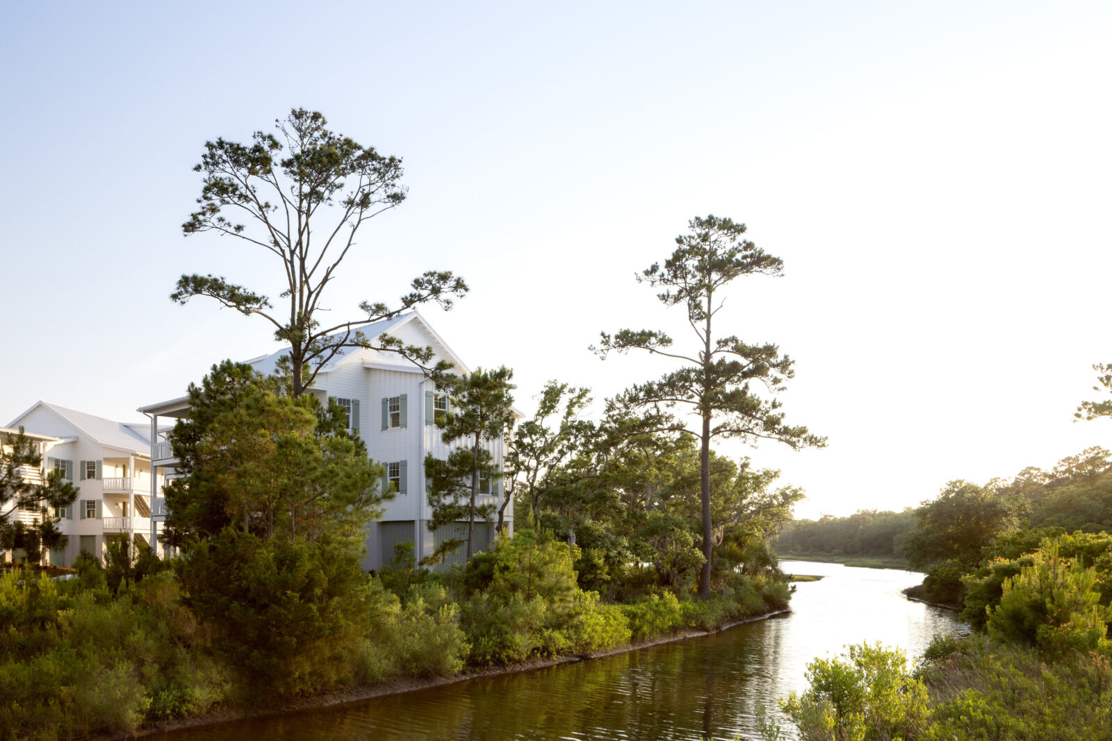 A large house resort sits on the edge of a river