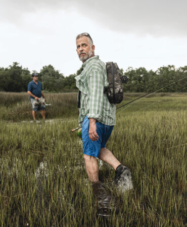 A man walks through a marsh