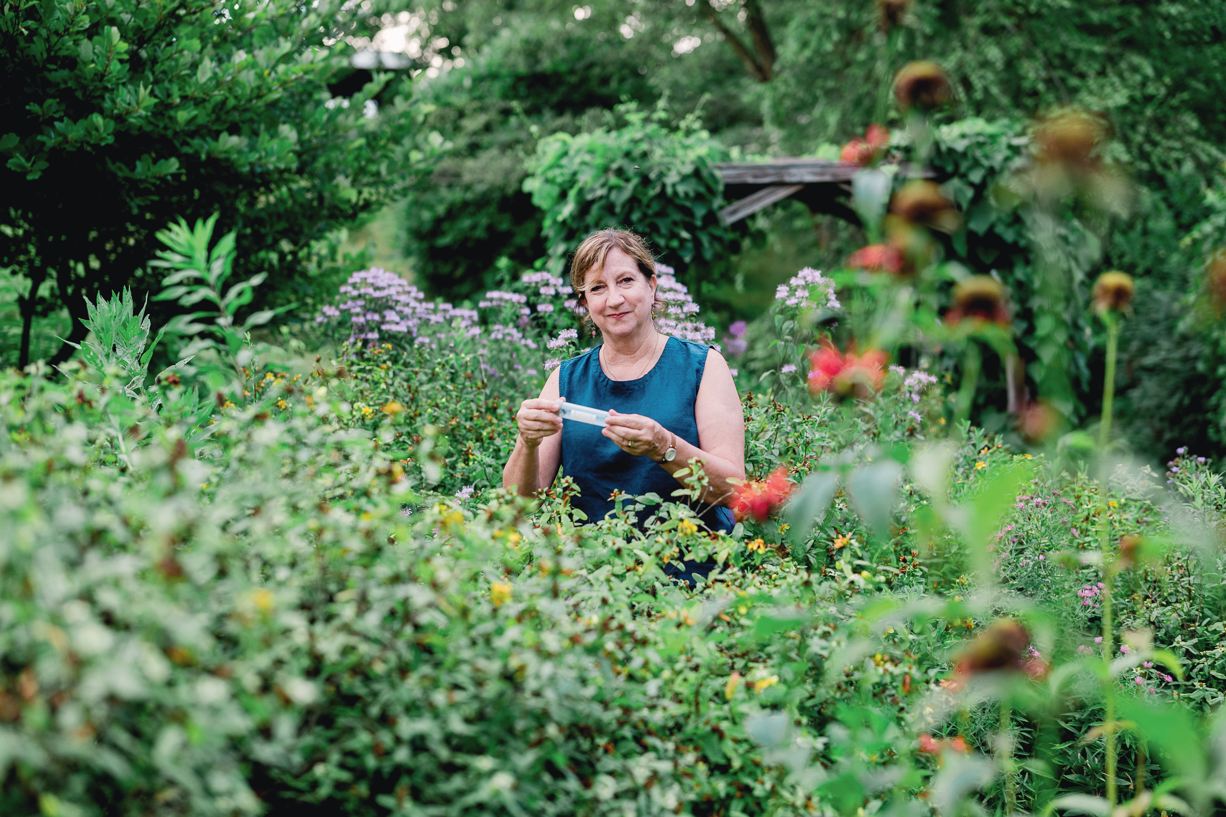 A woman stands in a field of flowers