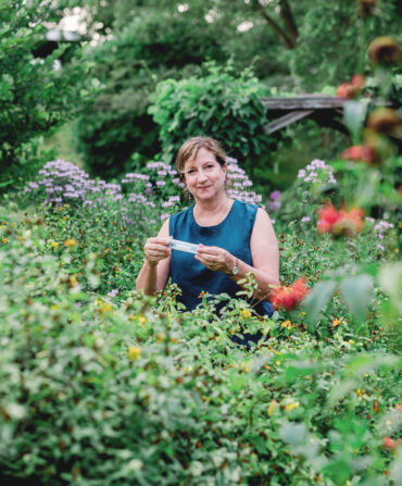 A woman stands in a field of flowers