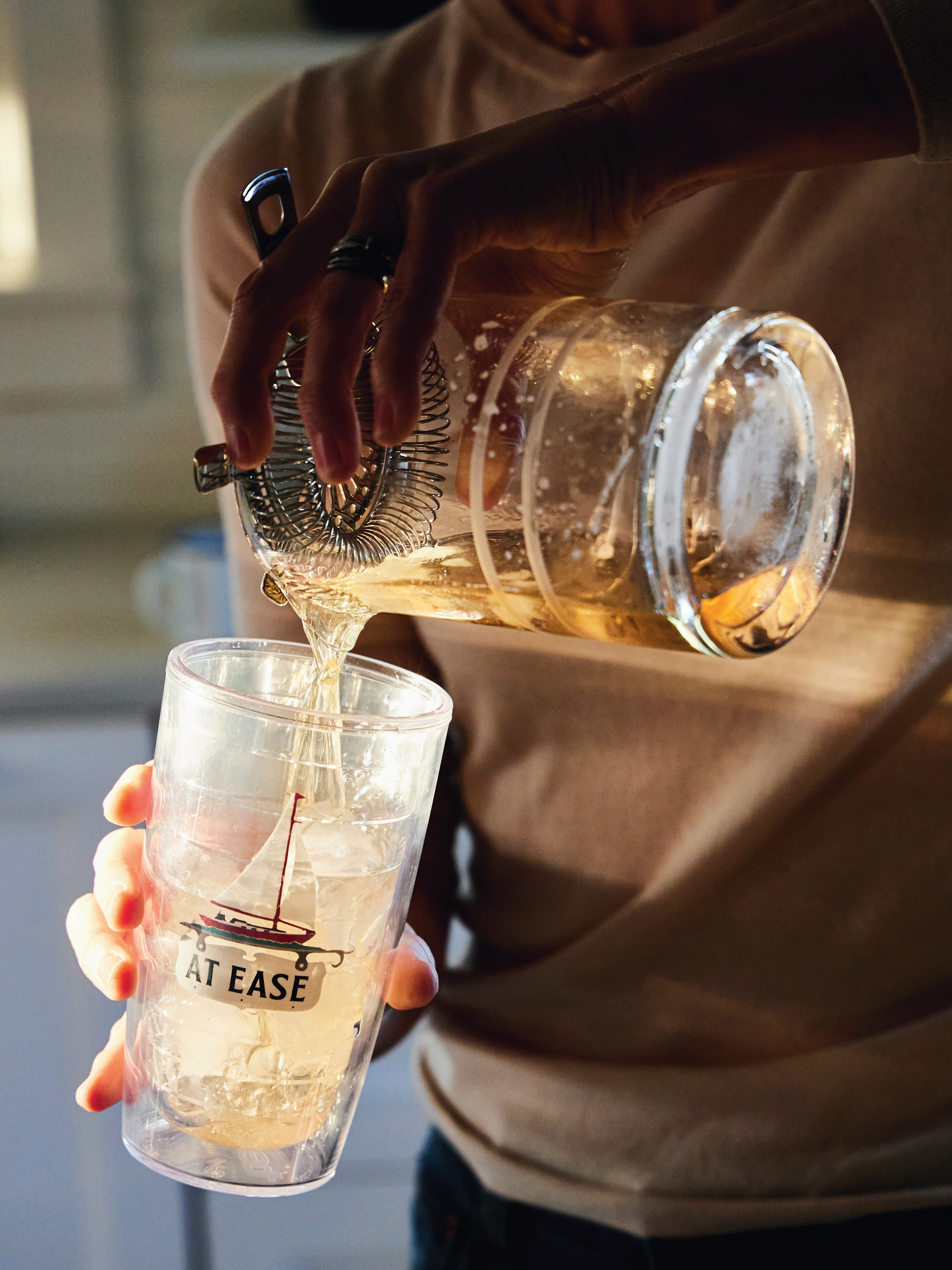 A hand pours a drink