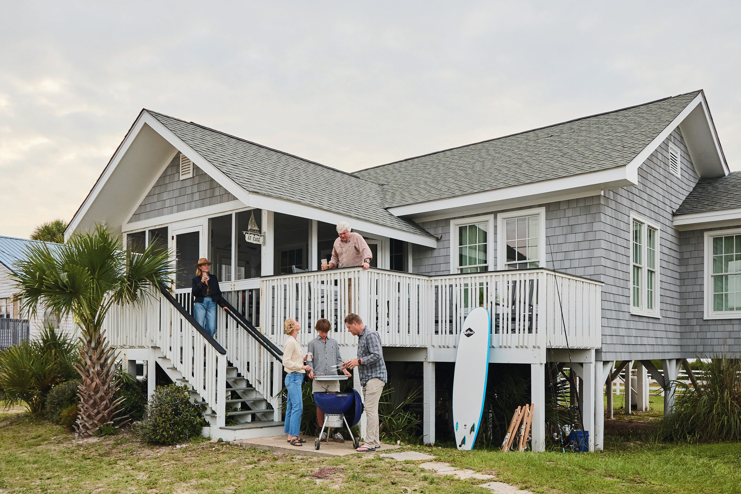 People stand outside a beach house